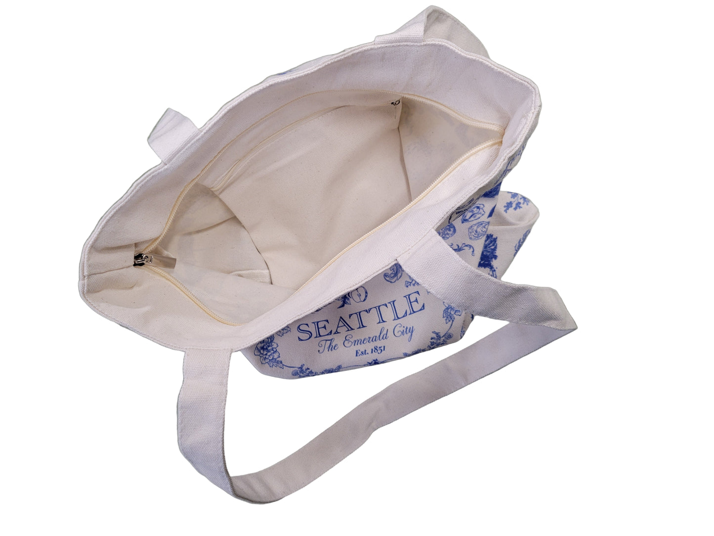 White tote bag with blue text and graphics on a light green surface